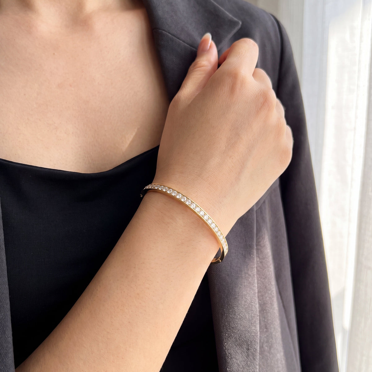 Yellow gold diamond bangle bracelet on hand
