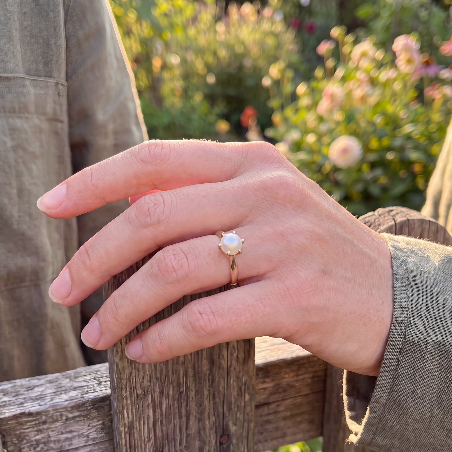 yellow gold pearl ring on finger 