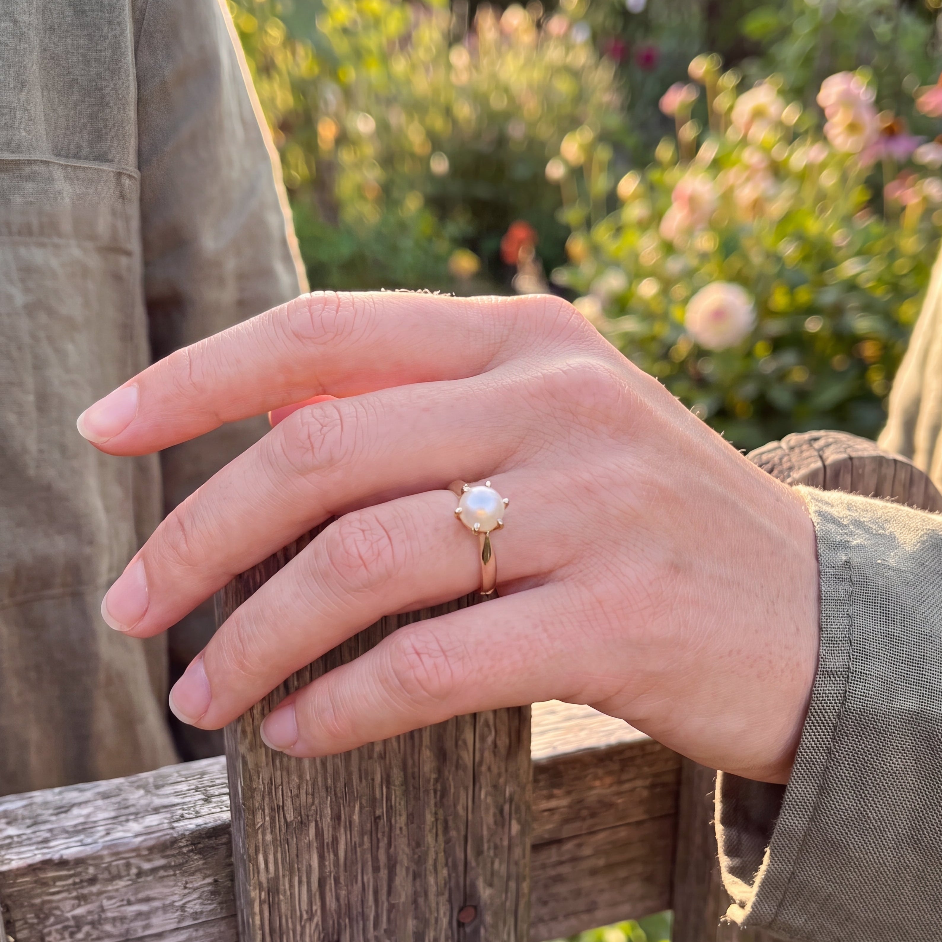 yellow gold pearl ring on finger 