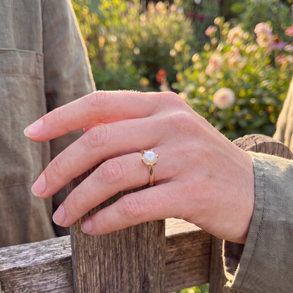 yellow gold pearl ring on finger 